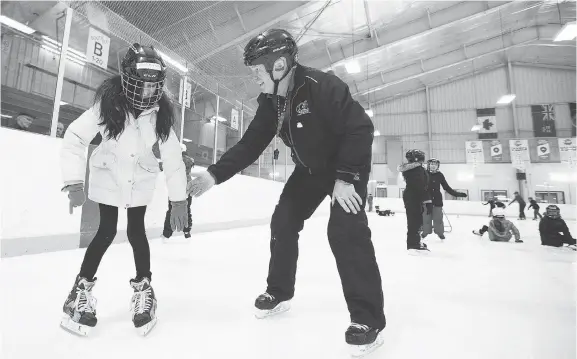  ?? PHOTOS: WAYNE CUDDINGTON ?? Ruggles Pritchard, who runs an initiation program for Hockey Eastern Ontario, helps Khadija Rasoul, 11, as kids from Blossom Park and General Vanier public schools take a skating lesson at Jim Durrell Arena. The program is part of a Hockey Canada effort to attract new fans and new players — immigrants in particular — to the game.