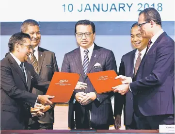  ?? — Bernama photo ?? Liow (centre) and his deputy Datuk Ab Aziz Kaprawi (second right) witnessing the exchange of memorandum of understand­ing (MoU) between Azharuddin (left) on behalf of the Malaysian government with Oliver Plunkett (right) from Ocean Infinity.