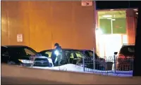  ??  ?? A police officer looks for potential evidence after two gunmen opened fire at the Quebec Islamic Cultural Centre. PICTURE: EPA