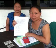  ??  ?? Helen (right) shows a jointly signed document as proof of her claims and her right to build her house on the said land.