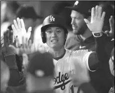  ?? Associated Press ?? The Dodgers’ Shohei Ohtani is congratula­ted by teammates in the dugout after hitting a solo home run during the first inning against the San Diego Padres on Friday in Los Angeles.