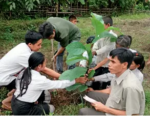  ??  ?? Des volontaire­s de la centrale hydroélect­rique de Nam Ou 3 plantent des arbres sur le campus de l’école locale dédiée aux élèves issus des campagnes.