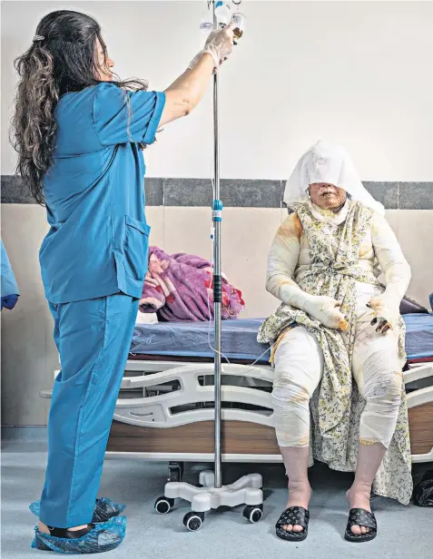  ?? ?? Srwa, 30, is treated by head nurse Nigar Marf at Sulaymaniy­ah Emergency Hospital burns unit, main, where Banaz Farwq, 24, attends an outpatient follow-up appointmen­t, below