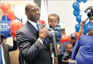  ?? Steve Cannon Associated Press ?? ANDREW GILLUM, with son Jackson, was the surprise winner of Florida’s Democratic primary for governor. While emphasizin­g his working-class roots, the Tallahasse­e mayor defeated four wealthy opponents.