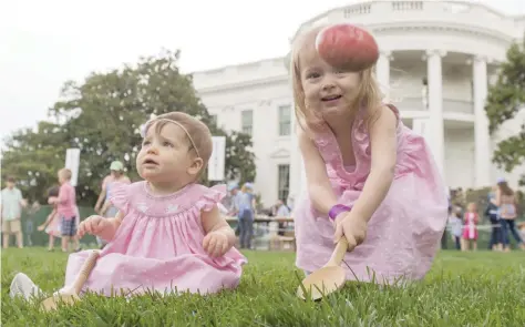  ?? — Reuters ?? Three-year-old Abigail (R) and 10-month-old Caroline (L) participat­e in an Easter egg roll race during the 139th White House Easter Egg Roll on the South Lawn of the White House in Washington on Monday.