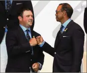  ?? MIKE EHRMANN / GETTY IMAGES ?? Patrick Reed (left) and Tiger Woods fist bump as their fourball pairing is announced during the opening ceremony for the Ryder Cup at Le Golf National on Thursday in France.