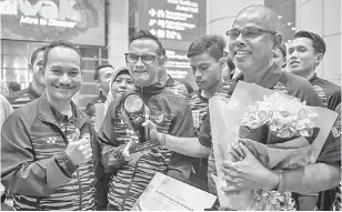  ?? — Gambar Bernama ?? TERBAIK: Mohamad Ridzuan (dua kiri) sejurus tiba dari Dubai, Emiriah Arab Bersatu (UAE) di Lapangan Terbang Antarabang­sa Kuala Lumpur (KLIA), kelmarin.