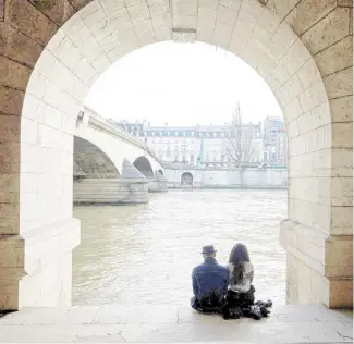  ?? DIMITAR DILKOFF/AGENCE FRANCE-PRESSE ?? COUPLE sits on the bank of the Seine river to enjoy the warm weather in Paris, France.