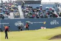  ?? PETER MORRISON/AP ?? Jordan Spieth of the United States putts on the 18th green on Friday at the British Open as a small contingent of fans brave the harsh conditions. He finished the day with a two-shot lead.