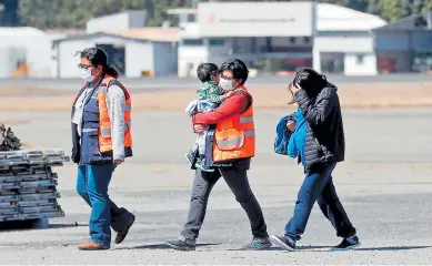  ??  ?? PROCESO. Una mujer embarazada y un menor de edad son acompañado­s por personal de Migración después de ser deportados.
