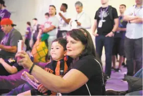  ??  ?? Left: Gamers at TwitchCon play “Starcraft II: Legacy of the Void.” Above: Stephana Femino holds son Jax Couchot, 3, on her lap while shooting a video.