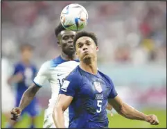  ?? Associated Press ?? Antonee Robinson of the United States (right) challenges for the ball with England’s Bukayo Saka during the World Cup Group B soccer match on Friday at the Al Bayt Stadium in Al Khor, Qatar. The two teams played to a scoreless draw.