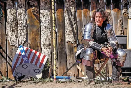  ?? PHOTOS BY GABRIELA CAMPOS/THE NEW MEXICAN ?? Elizabeth Escogne, a social worker, National Guard airman and award-winning fighter for the Armored Combat League, takes a rest following a bout Saturday at the Santa Fe Renaissanc­e Faire.