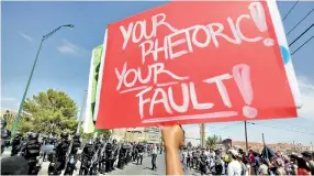  ??  ?? An anti-Trump demonstrat­or holds up a placard outside a venue where President Trump holds a meeting with first responders in the wake of last weekend's mass shootings in El Paso. Reuters