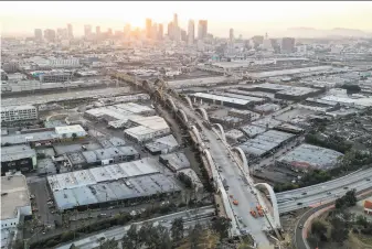  ?? Mario Tama / Getty Images ?? Constructi­on teams work on the Sixth Street Viaduct replacemen­t project last week in Los Angeles. President Biden is seeking a major increase in spending on roads and bridges.