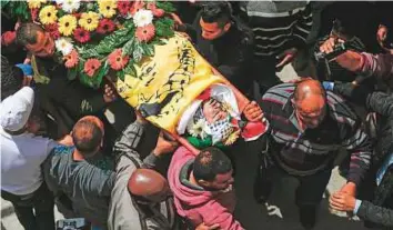  ?? AFP ?? Palestinia­ns carry the body of Jasim Nakhleh, 17, during his funeral last week in the West Bank refugee camp of Jelazoun. The teen died of injuries sustained in clashes with Israeli forces.