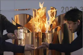  ?? EUGENE HOSHIKO — THE ASSOCIATED PRESS ?? Officials light a lantern from the Olympic Flame at the end of a ceremony March 25 in Iwaki, northern Japan.