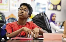  ?? THE COLUMBUS DISPATCH ?? Shrivatsan listens to his teacher before trying out for the science olympiad at New Albany Middle School. The 12-year-old entered the U.S. at 2.