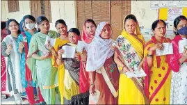  ?? ANI PHOTO ?? Women voters show their IDs while waiting in a queue to cast their votes for the seventh and final phase of UP assembly elections, at a polling station, in Varanasi on Monday.