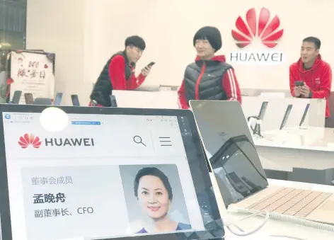  ??  ?? Una tienda de Huawei en Beijing, China, despliega en una computador­a la fotografía de Meng Wanzhou, la directora financiera de la empresa detenida en Canadá.