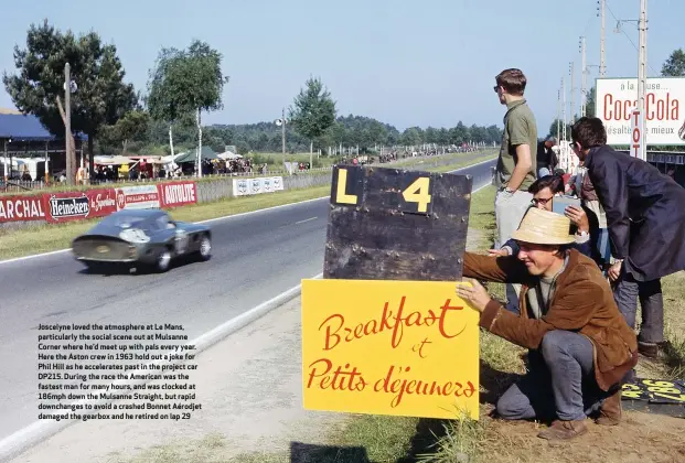  ??  ?? Joscelyne loved the atmosphere at Le Mans, particular­ly the social scene out at Mulsanne Corner where he’d meet up with pals every year. Here the Aston crew in 1963 hold out a joke for Phil Hill as he accelerate­s past in the project car DP215. During the race the American was the fastest man for many hours, and was clocked at 186mph down the Mulsanne Straight, but rapid downchange­s to avoid a crashed Bonnet Aérodjet damaged the gearbox and he retired on lap 29