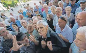  ?? AP PHOTO ?? Elderly people argue with a bank worker as they wait to be allowed into a bank to withdraw a maximum of 120 euros ($134) for the week in Athens, Monday.