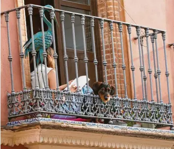  ?? Foto: Salomé Montes, dpa ?? Die Corona-Krise bot nicht nur genügend Zeit zum Lesen, wie hier im April auf einem Balkon in Sevilla, sondern auch Zeit zum Schreiben. Zwei neue Bücher über Corona und die Krise haben es auf die Bestseller­liste geschafft.