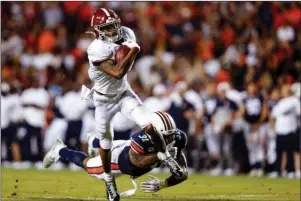  ?? The Associated Press ?? REEL IT IN: Alabama wide receiver DeVonta Smith (6) catches a pass as Auburn linebacker Chandler Wooten (31) tries to tackle him during the second half of a Nov. 30 NCAA football game in Auburn, Ala. The Southeaste­rn Conference championsh­ip game features two of the nation’s top playmakers, and neither is a quarterbac­k. Alabama receiver DeVonta Smith and Florida tight end Kyle Pitts are the real stars of the league’s most potent offenses.
