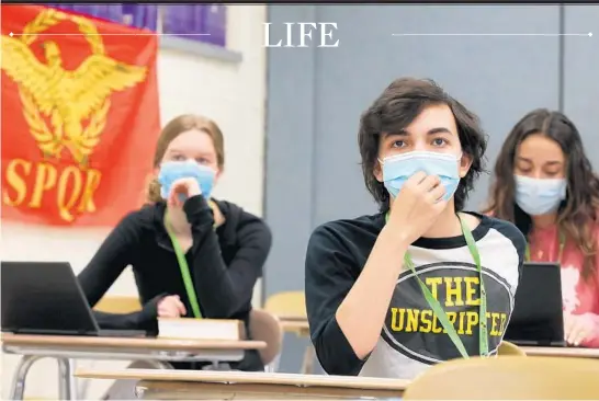  ?? ANTONIO PEREZ/CHICAGO TRIBUNE PHOTOS ?? Students Molly Savage, from left, Matthew Leonardson and Jeanette Kristev participat­e in an advanced placement Latin class at Hinsdale South High School. Mandatory mask wearing has made it tough for both teachers and students to work on speaking skills.