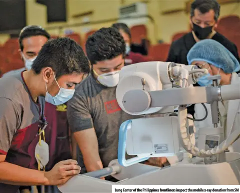  ??  ?? Lung Center of the Philippine­s frontliner­s inspect the mobile x-ray donation from SM
