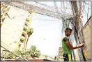  ??  ?? A man checks the wiring on electric cables reaching out to homes in Saadoun Street in the Iraqi capital Baghdad on July 29, as chronic power shortages have forced residents to buy electricit­y from private entreprene­urs who run generators visible on street corners across the country. Iraqi Prime Minister Haider al-Abadi sacked his minister of electricit­y on July 29 after three weeks of protests against corruption. (AFP)