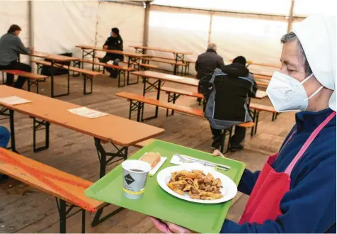 ?? Foto: Silvio Wyszengrad ?? Schwester Stephanie verteilt Essen, damit Obdachlose auch in Corona‰Zeiten nicht ohne Hilfe bleiben. Wegen der Pandemie versorgt der Sozialverb­and SKM derzeit in einem großen Zelt die Menschen mit Essen.