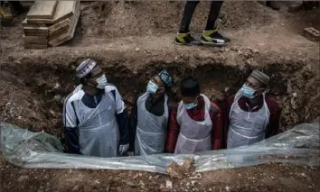  ?? Shiraaz Mohamed/Associated Press ?? Members of the Saaberie Chishty Burial Society prepare a grave for a person who died from COVID-19. The were at the Avalon Cemetery in Lenasia, Johannesbu­rg, on Saturday.