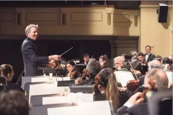  ?? Photo by Matt Fried ?? New Haven Symphony Orchestra music director and conductor Alasdair Neale leads the orchestra in a 2019 performanc­e.