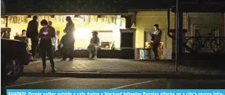  ?? — AFP ?? KHARKIV: People gather outside a cafe during a blackout following Russian attacks on a city’s energy infrastruc­ture in Kharkiv, on April 8, 2024.