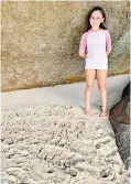  ??  ?? It all adds up: for Mara, 8, homeschool­ing means writing prime numbers in the sand