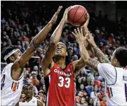  ??  ?? Georgia forward Nicolas Claxton, who had 15 points and six blocks, looks to shoot over Auburn’s Anfernee McLemore and J’Von McCormick.