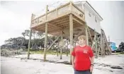  ?? ALICIA DEVINE/TALLAHASSE­E DEMOCRAT ?? Tonya McNabb, an Alligator Point resident, stands on the shoreline in front of her home Oct. 7. McNabb’s deck and stairs to enter her home were ripped from her house by Hurricane Michael in October 2018.