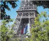  ??  ?? The French national flag adorns the Eiffel Tower.