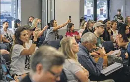  ?? Gina Ferazzi Los Angeles Times ?? AUDIENCE MEMBERS take video at a contentiou­s school board meeting in Temecula over LGBTQ+ history in the district’s textbooks on July 18.