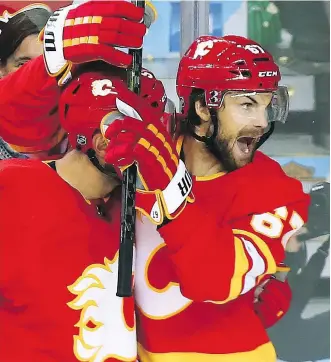  ?? GAVIN YOUNG ?? Flames winger Michael Frolik celebrates with Mark Giordano after scoring his second goal of the night during Wednesday’s 5-2 victory over the Bruins at the Scotiabank Saddledome.