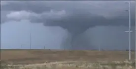  ?? THE WICHITA EAGLE VIA AP ?? A tornado passes south-central Kansas on Friday. The tornado damaged multiple buildings, injured several people and left more than 6,500 people without power, and three dead.