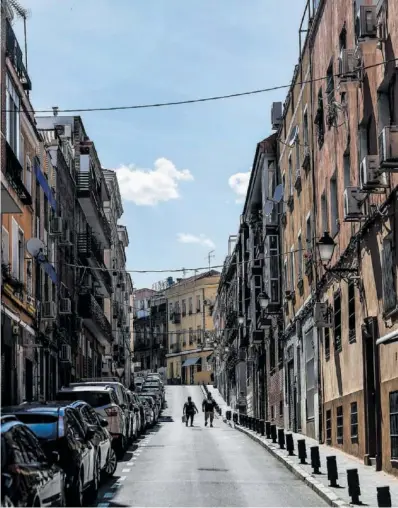  ?? ÁLVARO GARCÍA ?? Dos personas caminaban el martes por una calle del barrio de la Puerta del Ángel.