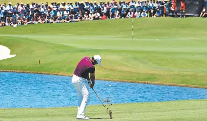  ?? Picture: AAP ?? Jason Day chips to the ninth green yesterday on his way to a five-under 66 to be three behind.