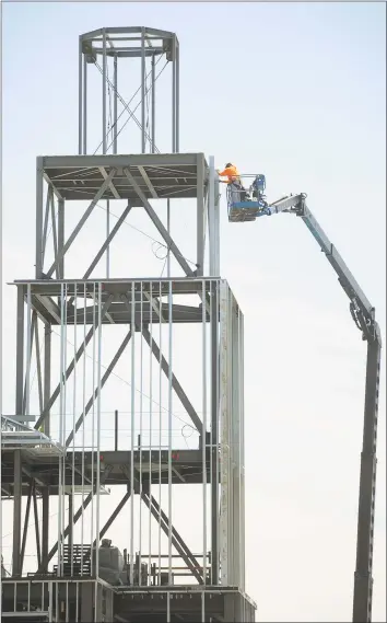  ?? Hearst Connecticu­t Media file photo ?? A constructi­on worker uses a crane in May to access the steel frame of the Dockmaster Building, part of the Steelpoint­e Harbor developmen­t project in Bridgeport.