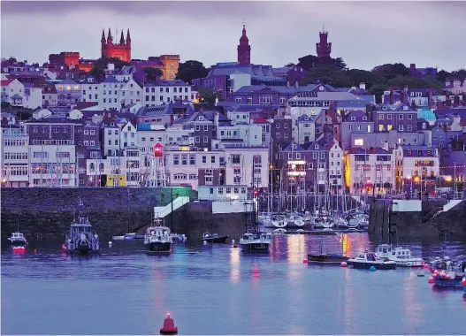  ??  ?? Saint Peter Port, die Hauptstadt der Kanalinsel Guernsey, liegt auch architekto­nisch zwischen Großbritan­nien und Frankreich: Die Festung und der Wehrturm muten britisch an, die heimeligen Wohnhäuser eher französisc­h.