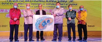  ??  ?? Yong (second left) presenting a drawing of the Double Blue Holes at Darvel Bay painted by Professor Dato’ Dr Wilson Yong Tung Yung (third left) to Tiong. Also seen is Goh (left).