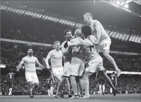  ??  ?? Bernardo Silva (fourth from right) of Manchester City celebrates scoring with teammates during their Premier League match against Chelsea at the Etihad Stadium on Sunday in Manchester, England.