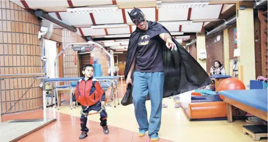  ??  ?? Acompañado de Batman, un paciente del Instituto Teletón de Valparaíso se dirige a hacer sus ejercicios de rehabilita­ción.