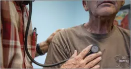  ?? PHOTO BY ANNE WERNIKOFF FOR CALMATTERS ?? A doctor listens to a man's heart beat at a clinic in Bieber, Calif., in 2019. Covered
California premiums will rise 6%, a smaller increase than seen in other
states.